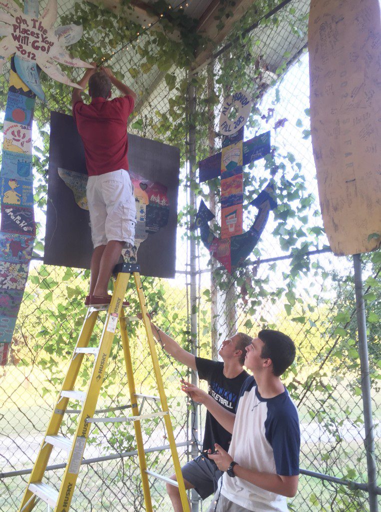 Volunteers Ben Draper, Ethan Kramer, and Ryan Egan help string lights for the dance.